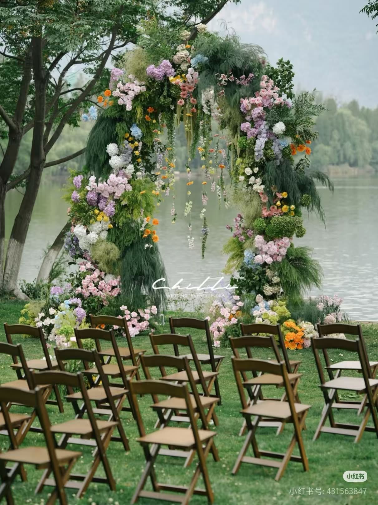 湖畔花艺拱门与木质折叠椅